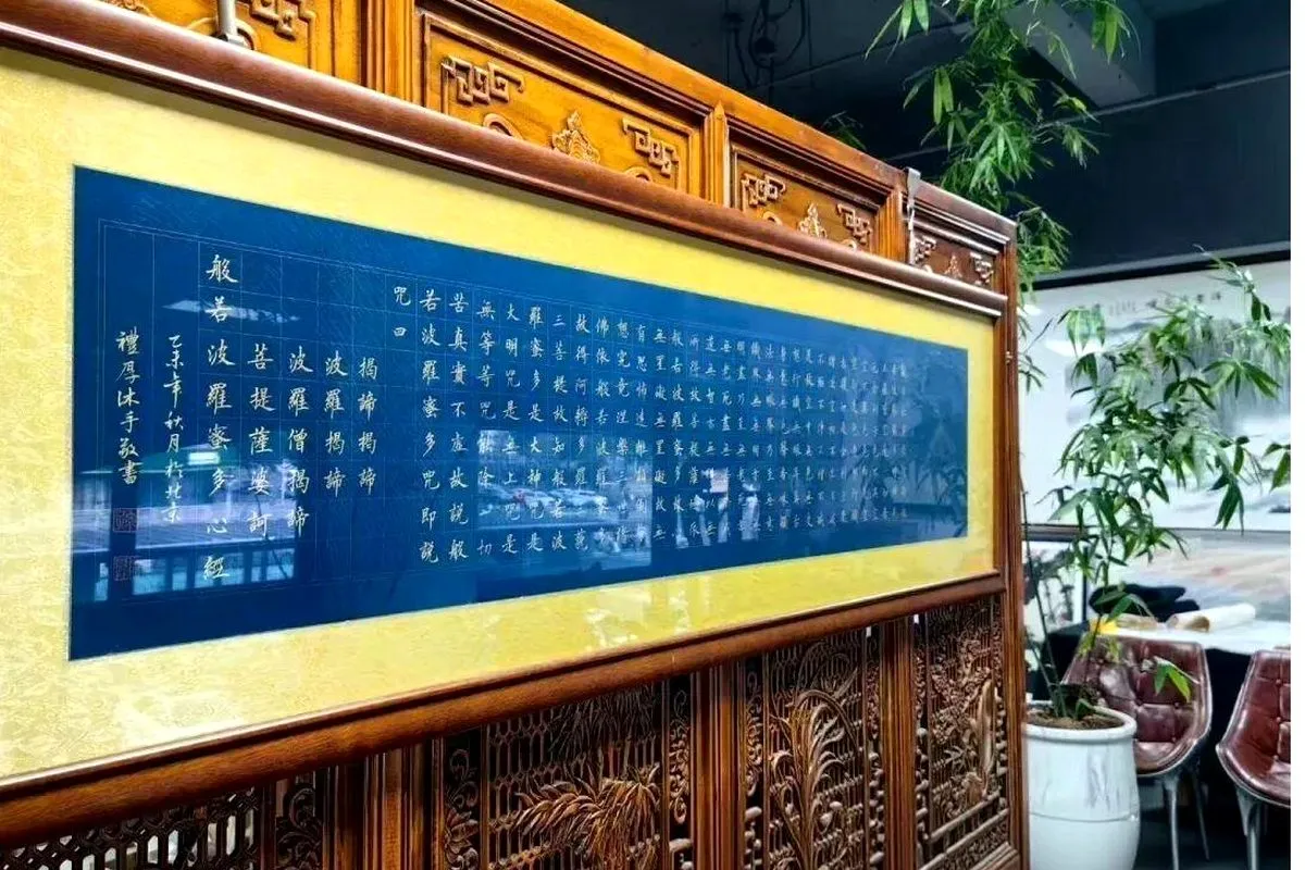 A study of the Heart Sutra brushed by Artist Lina Sun in Xiao Kai (small-character calligraphy), mounted in a traditional blue and gold frame